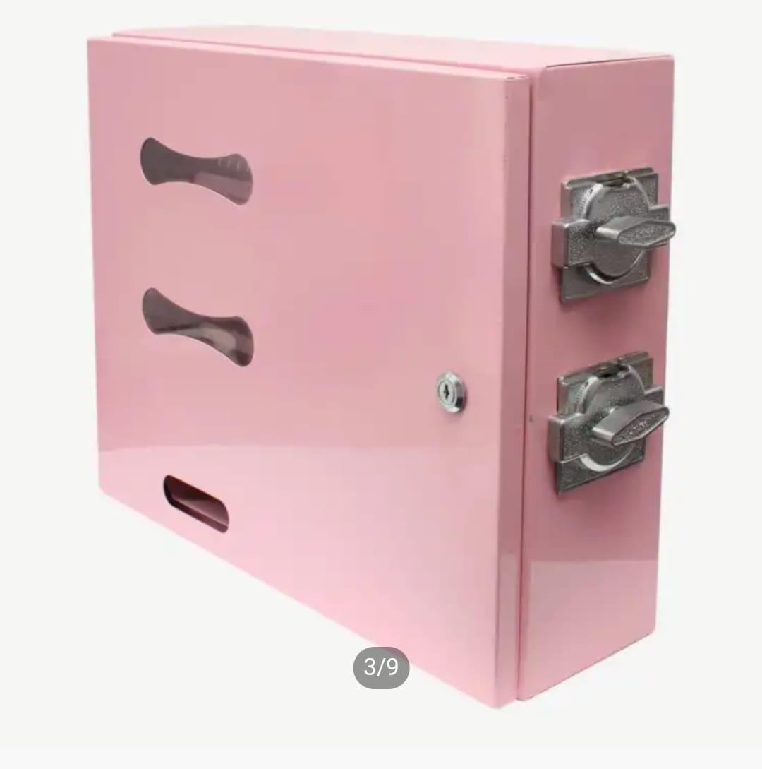 Perspective view of a pink manual sanitary pad dispenser showing side mechanical coin-turn knobs and viewing windows.