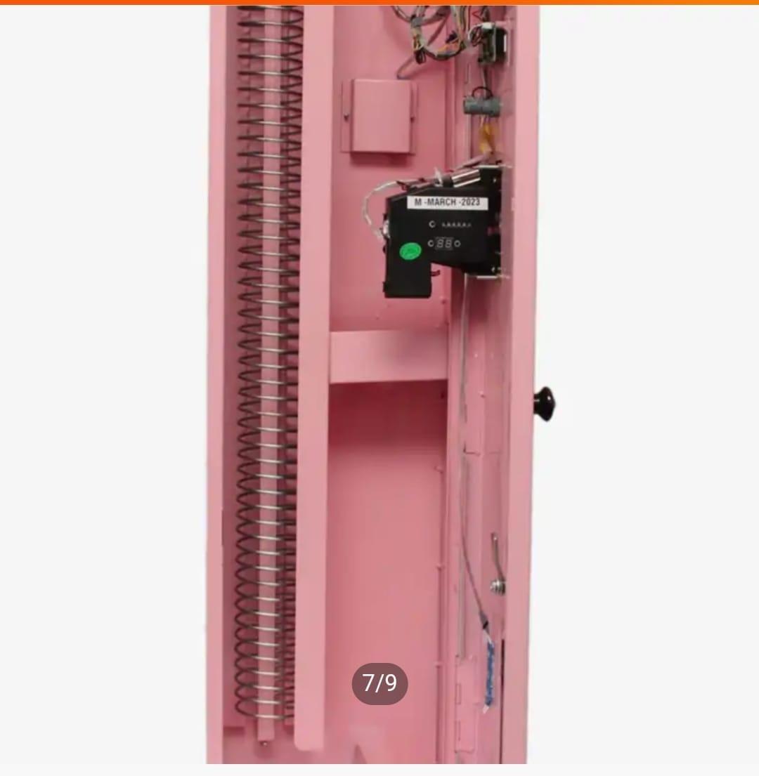 Internal dispensing mechanism and electronic circuit controller inside a pink automated vending machine unit.