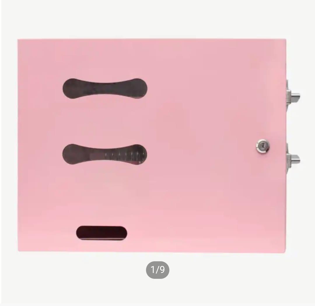 Front view of a pink compact manual sanitary pad vending machine with stock inspection windows and key lock.