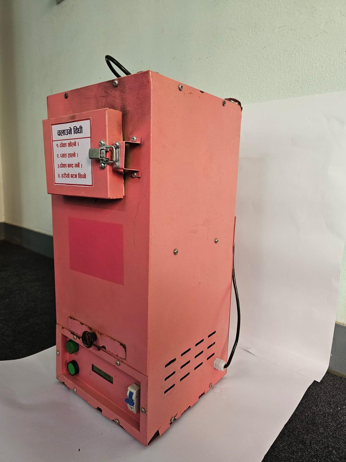 Perspective view of a pink sanitary napkin disposal machine featuring side ventilation slots and front control panel.
