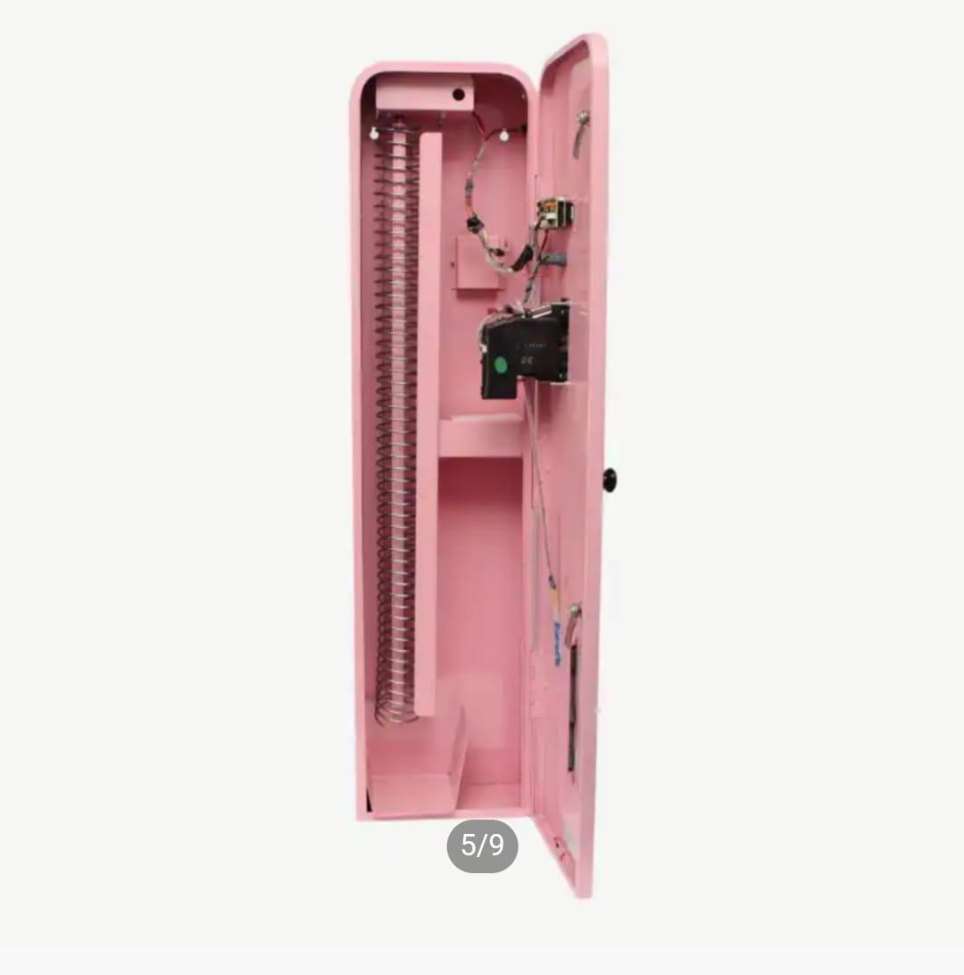 Open side view displaying the internal product coil dispenser mechanism and coin validation system of a wall-mounted vending machine.